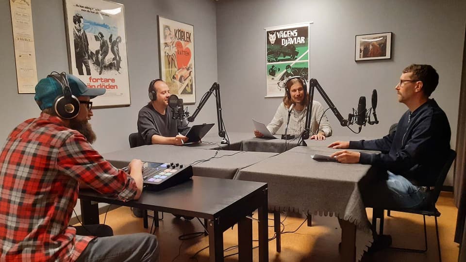 Personer sitter i en radiostudio