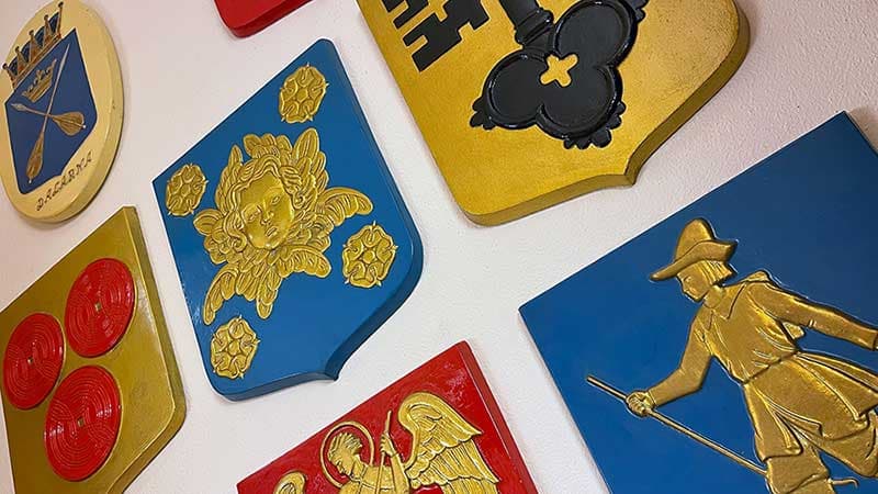 Heraldiska kommunvapen på en vägg