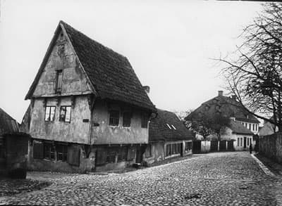 Ett äldre fotografi som visar en kullerstensgata och hus.