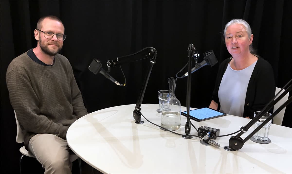 Två personer vid ett bord med mikrofoner