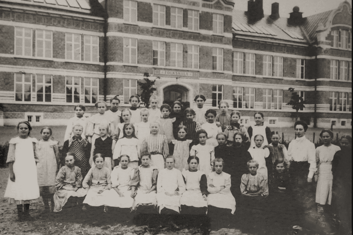 En skolklass framför en stor byggnad